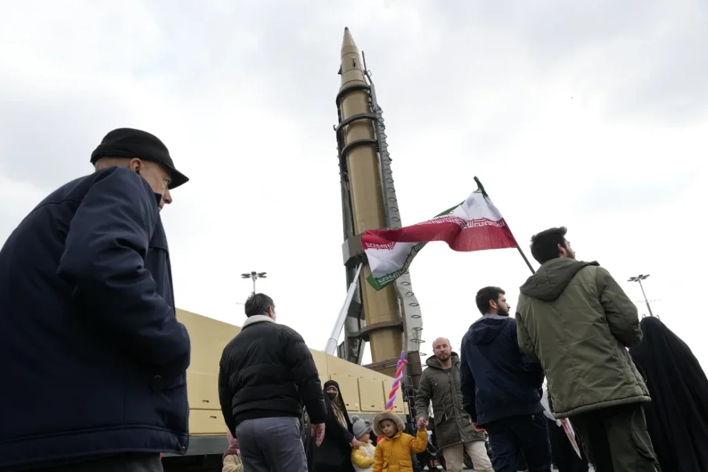 Iranian demonstrators beside a missile at a Tehran rally